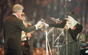 Stevie Nicks of Fleetwood Mac passes a tambourine to president-elect Bill Clinton during the finale of the Presidential Gala, Jan. 19, 1993 at the Capital Centre in Landover, Md. (Photo by the AP's Amy Sancetta)